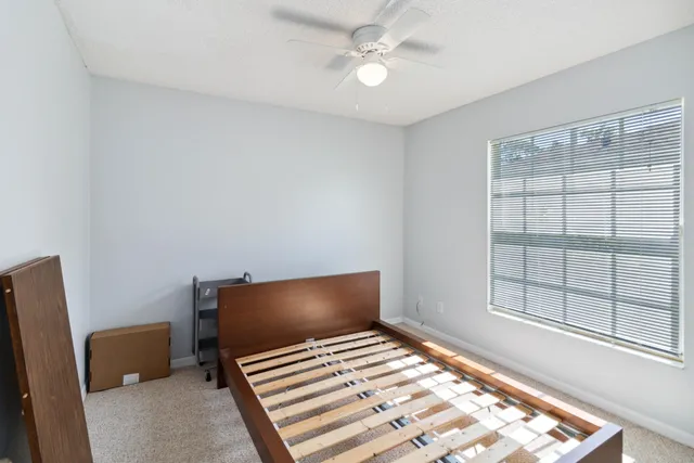 a bedroom with a bed and a large window