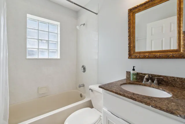 a bathroom with a granite countertop sink toilet and a bathtub