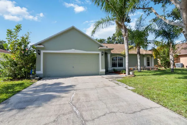 a front view of a house with a garden and trees