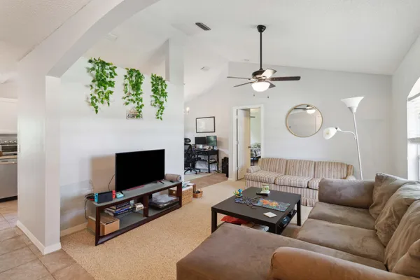 a living room with furniture a flat screen tv and a fireplace