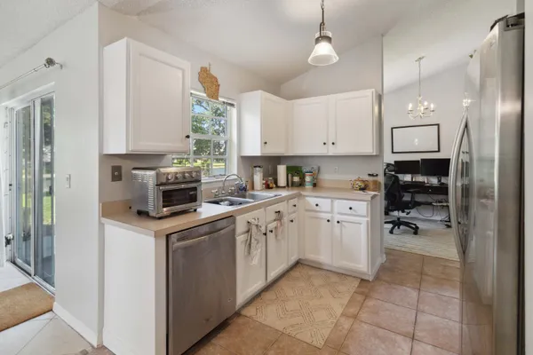 a kitchen with cabinets appliances a sink and a window