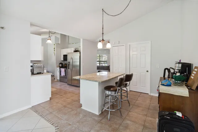 a view of a dining room with furniture and a kitchen view