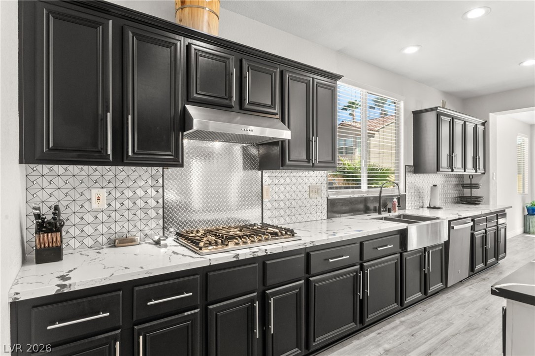 5601 Rocky Ravine Avenue Las Vegas, NV 89131 - Photo 20 of 71 Kitchen featuring dark cabinetry, light stone countertops, and recessed lighting