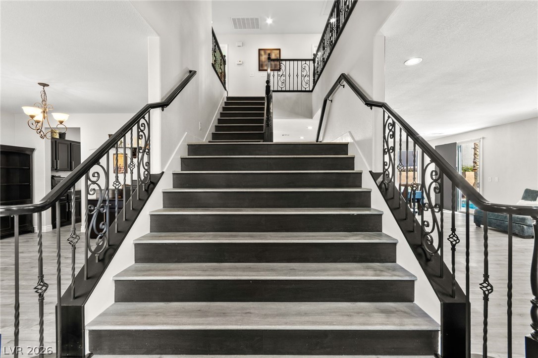 5601 Rocky Ravine Avenue Las Vegas, NV 89131 - Photo 33 of 71 Staircase featuring hanging lights and wood finished floors