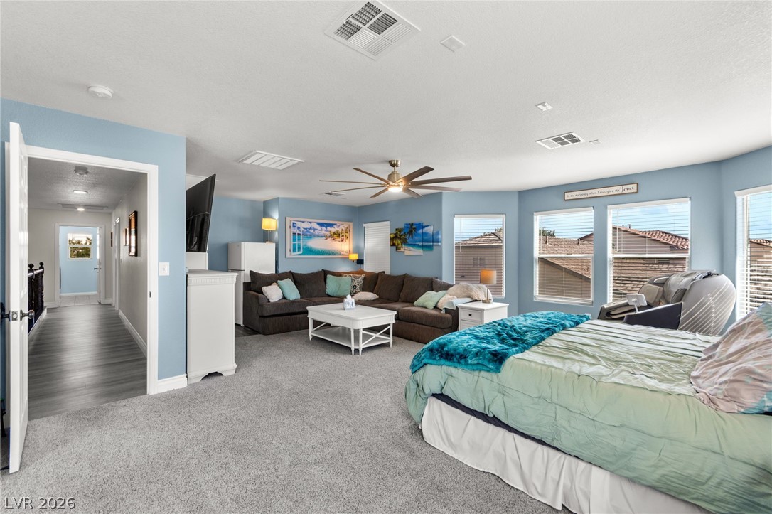 5601 Rocky Ravine Avenue Las Vegas, NV 89131 - Photo 38 of 71 Primary Bedroom featuring light carpet, ceiling fan, and a textured ceiling