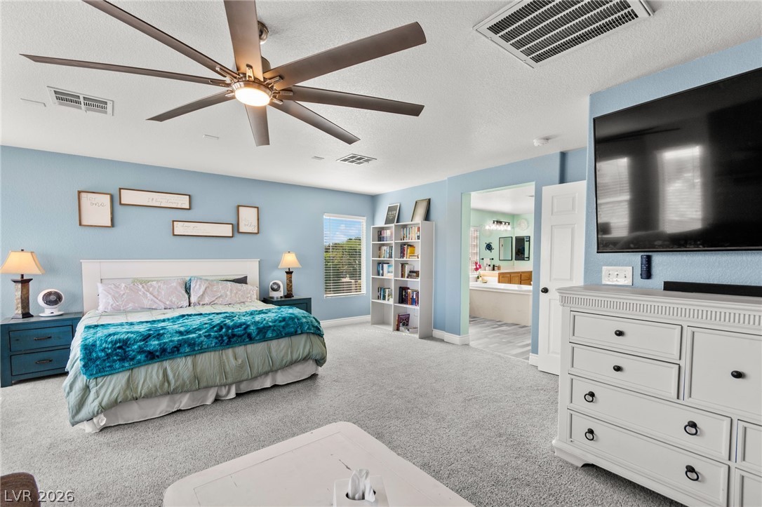 5601 Rocky Ravine Avenue Las Vegas, NV 89131 - Photo 39 of 71 Bedroom featuring light colored carpet, a textured ceiling, ceiling fan, and ensuite bathroom