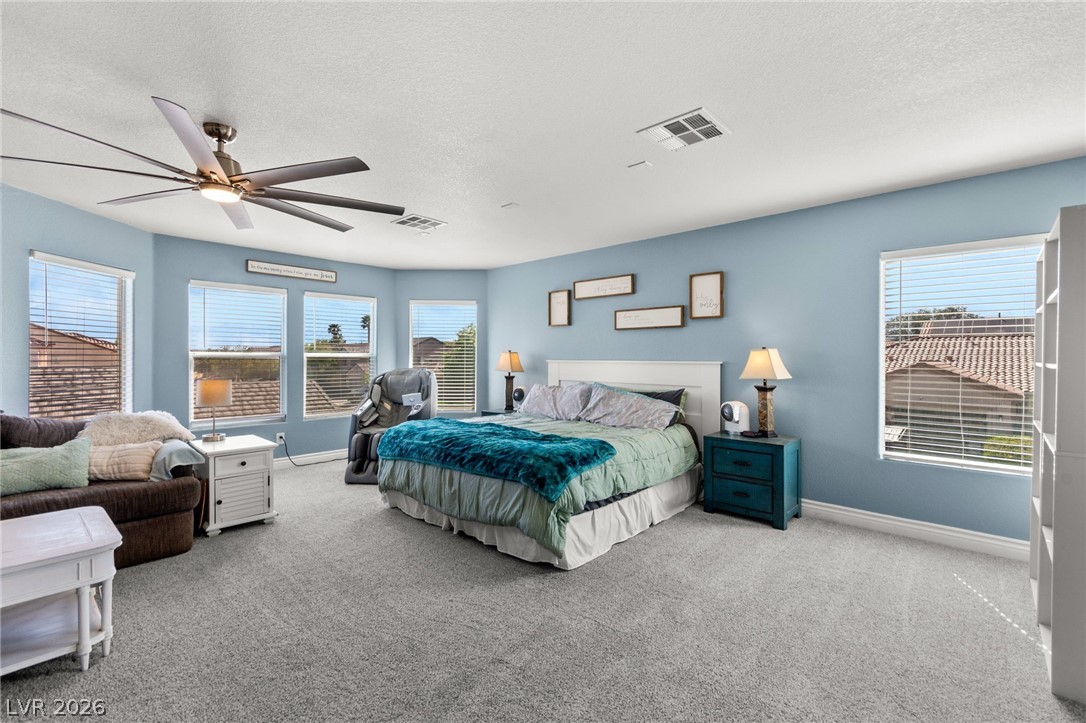 5601 Rocky Ravine Avenue Las Vegas, NV 89131 - Photo 40 of 71 Primary Bedroom featuring light carpet, ceiling fan, and a textured ceiling