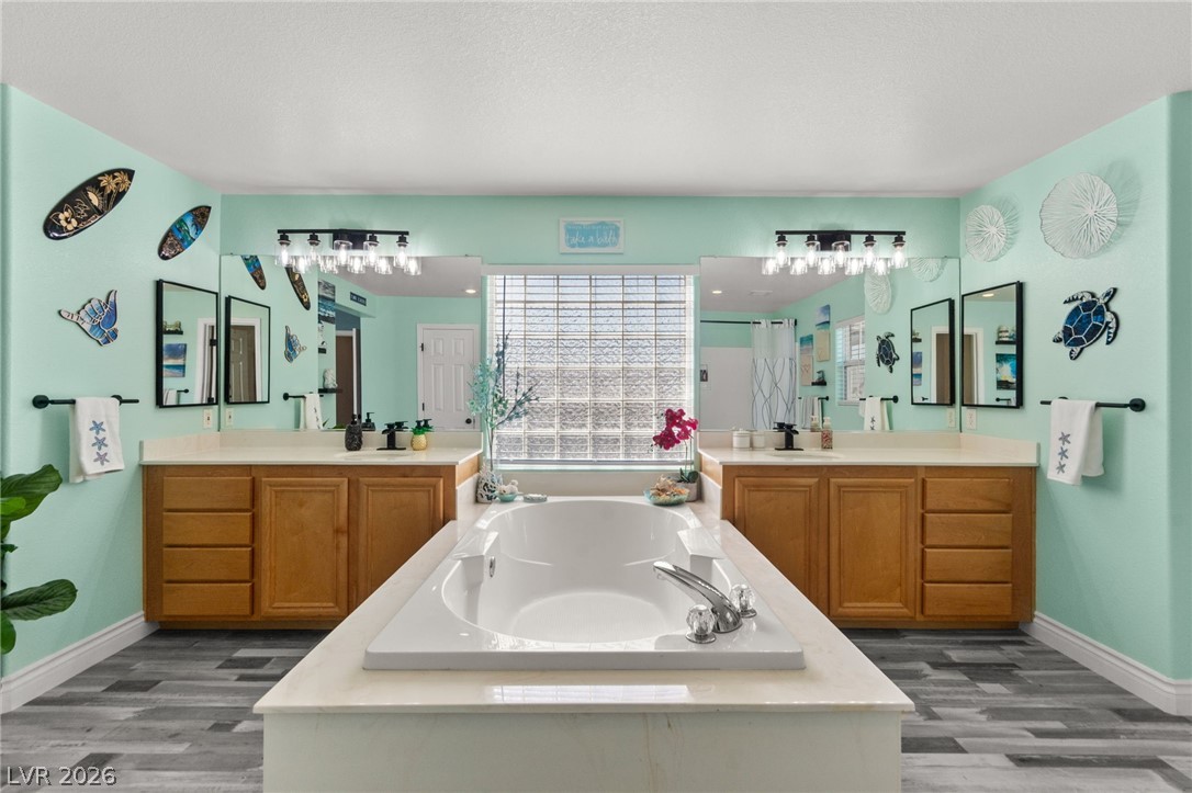 5601 Rocky Ravine Avenue Las Vegas, NV 89131 - Photo 45 of 71 Full bathroom with a garden tub, a stall shower, two vanities, and dark wood-style floors