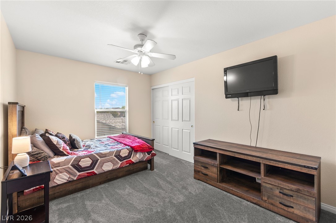 5601 Rocky Ravine Avenue Las Vegas, NV 89131 - Photo 50 of 71 Bedroom with dark colored carpet, a closet, and ceiling fan
