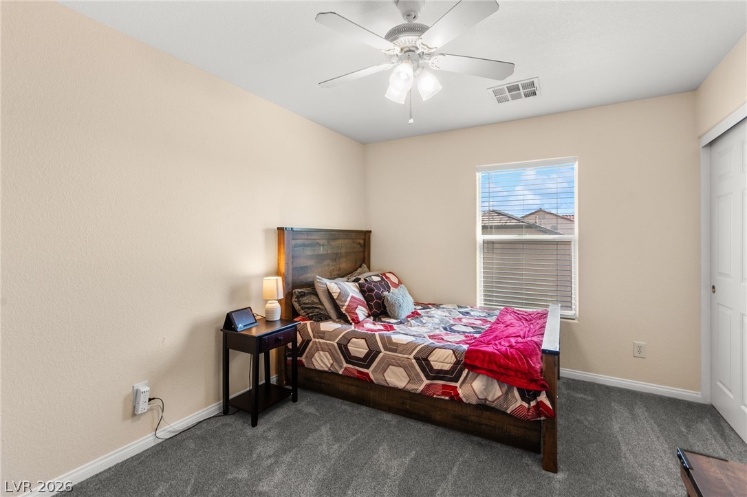 5601 Rocky Ravine Avenue Las Vegas, NV 89131 - Photo 51 of 71 Bedroom with dark colored carpet, a ceiling fan, and a closet