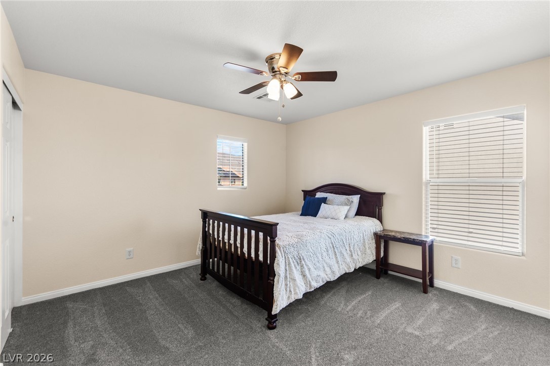 5601 Rocky Ravine Avenue Las Vegas, NV 89131 - Photo 56 of 71 Bedroom with dark carpet, a ceiling fan, and a closet