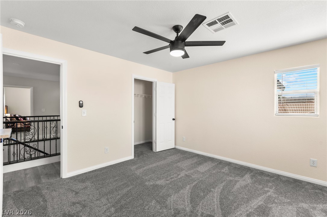 5601 Rocky Ravine Avenue Las Vegas, NV 89131 - Photo 61 of 71 Unfurnished bedroom featuring dark carpet, ceiling fan, and a closet