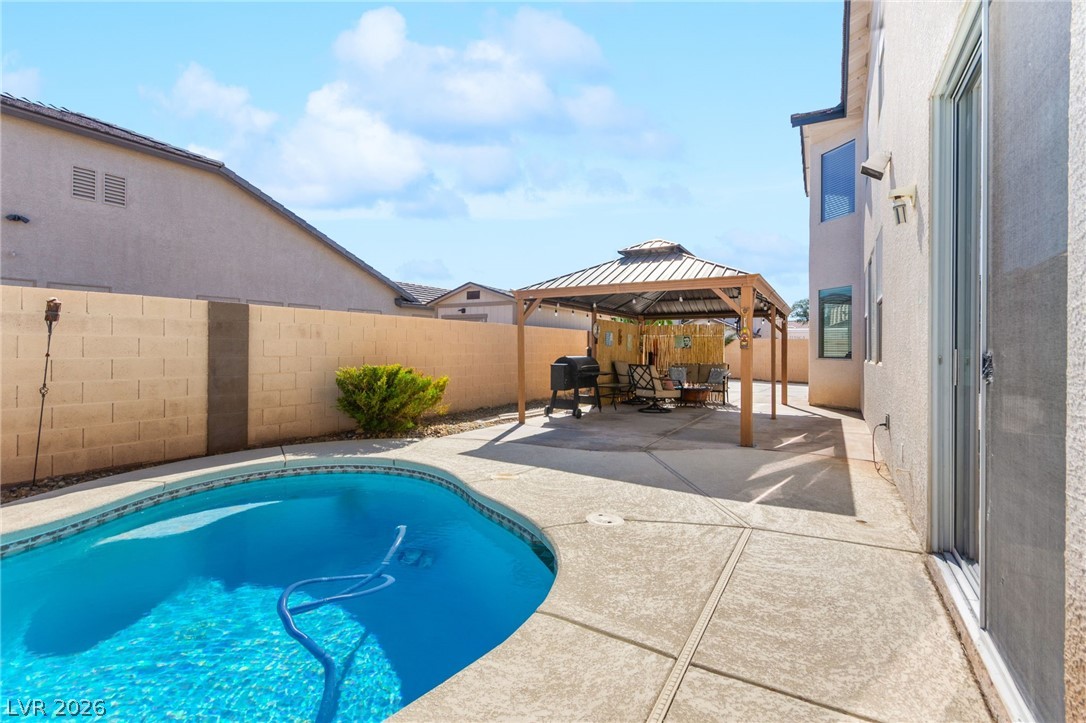 5601 Rocky Ravine Avenue Las Vegas, NV 89131 - Photo 70 of 71 View of swimming pool featuring patio surround, a gazebo, a fenced backyard, and area for grilling