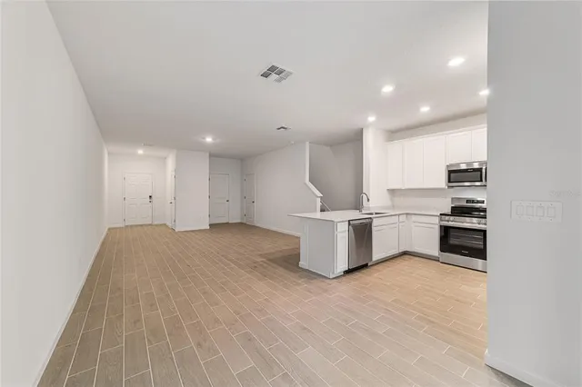 a view of kitchen with wooden floor and electronic appliances