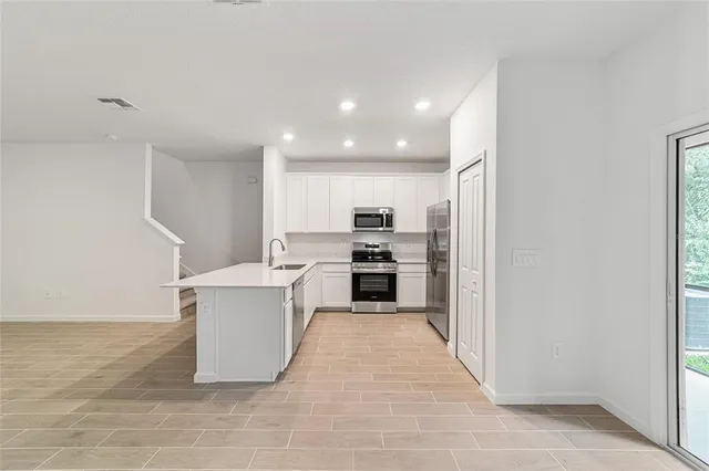 a kitchen with stainless steel appliances a refrigerator stove microwave and sink