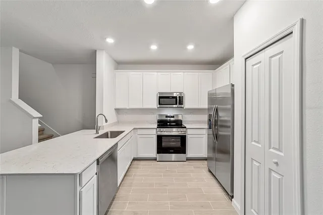 a kitchen with stainless steel appliances a refrigerator and a sink