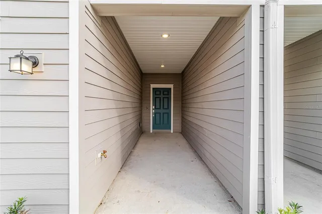 a view of a hallway with wooden floor and a kitchen