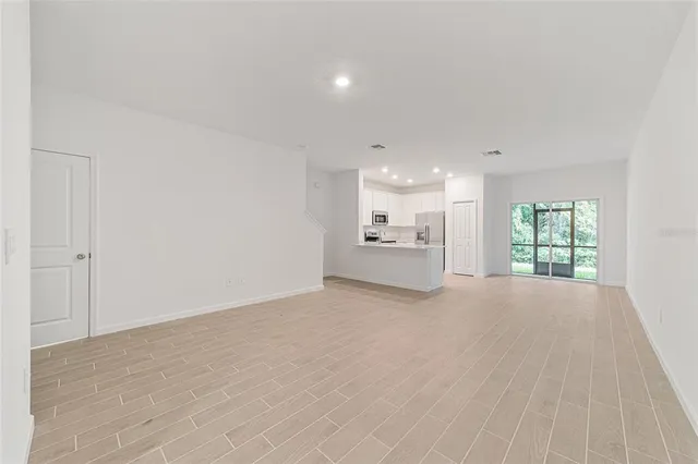 a view of kitchen with refrigerator sink and cabinets