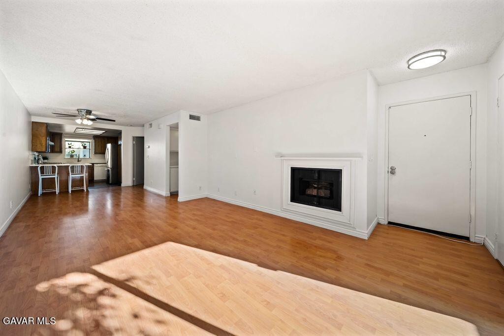 20345 Rue Crevier, Unit 507 Santa Clarita, CA 91351 - Photo 2 of 20 a view of empty room with wooden floor and fireplace