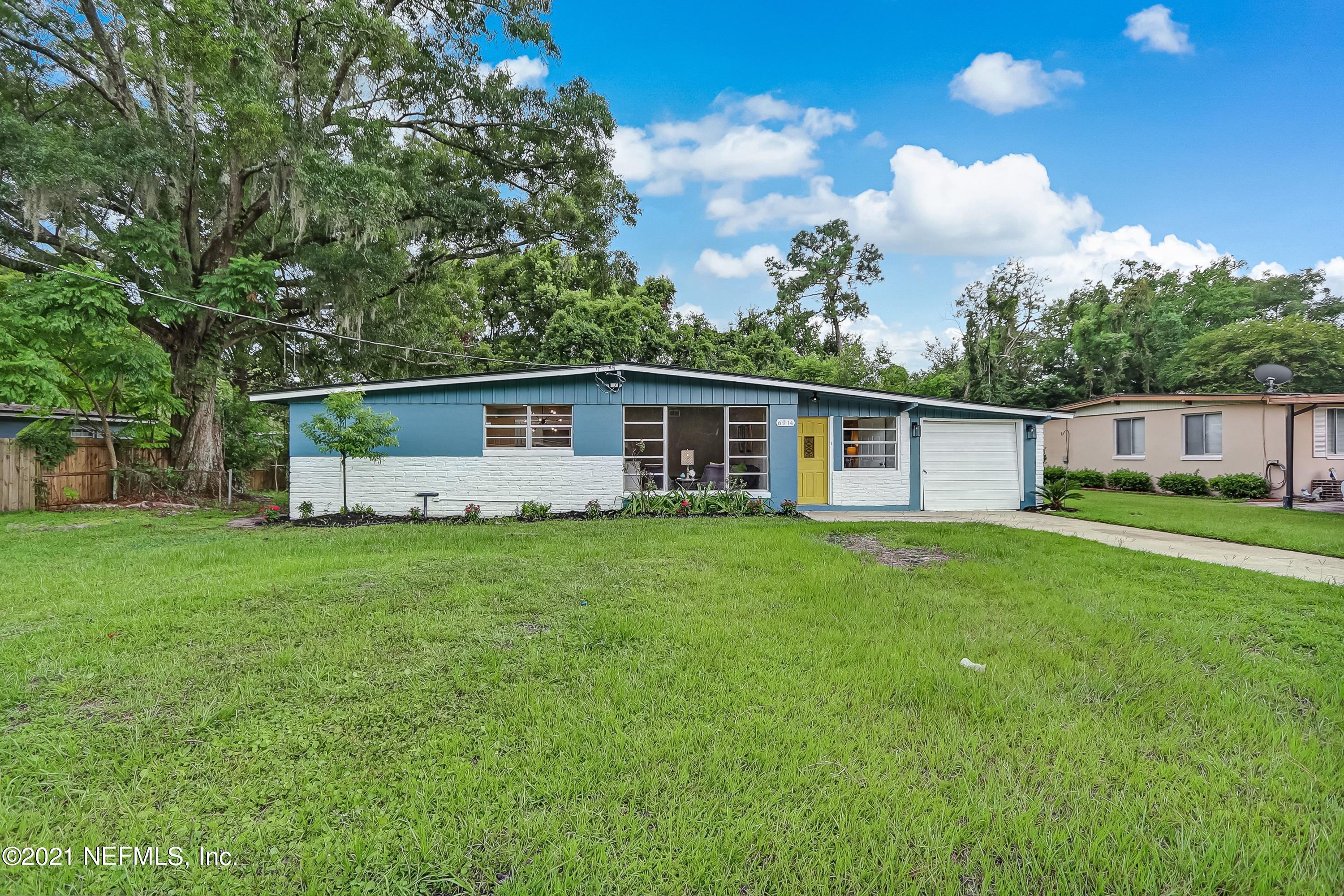 6914 Rollo Road Jacksonville, FL 32205 - Photo 1 of 31 a front view of a house with a yard and trees