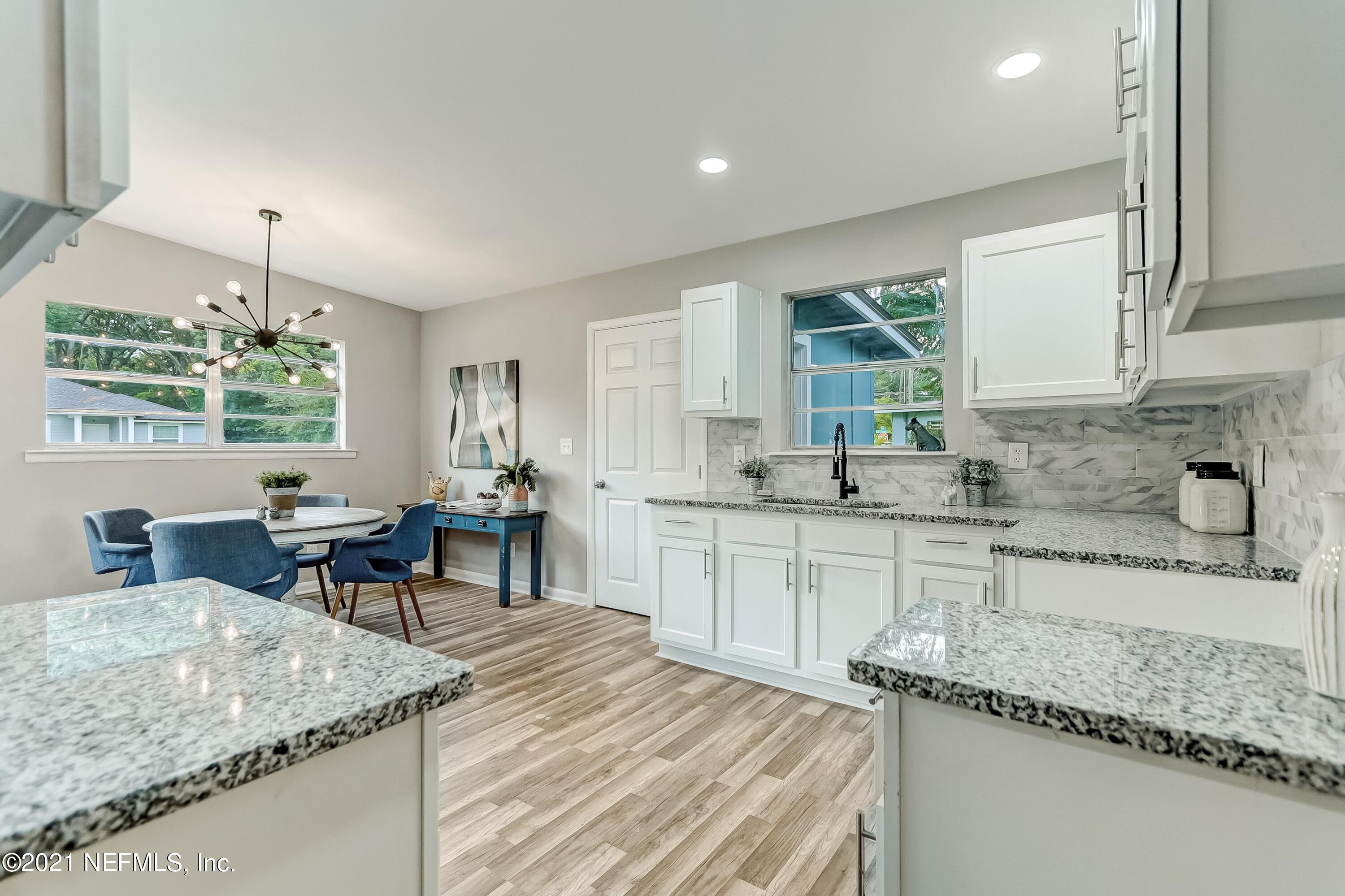 6914 Rollo Road Jacksonville, FL 32205 - Photo 12 of 31 a kitchen with stainless steel appliances granite countertop sink stove and cabinets