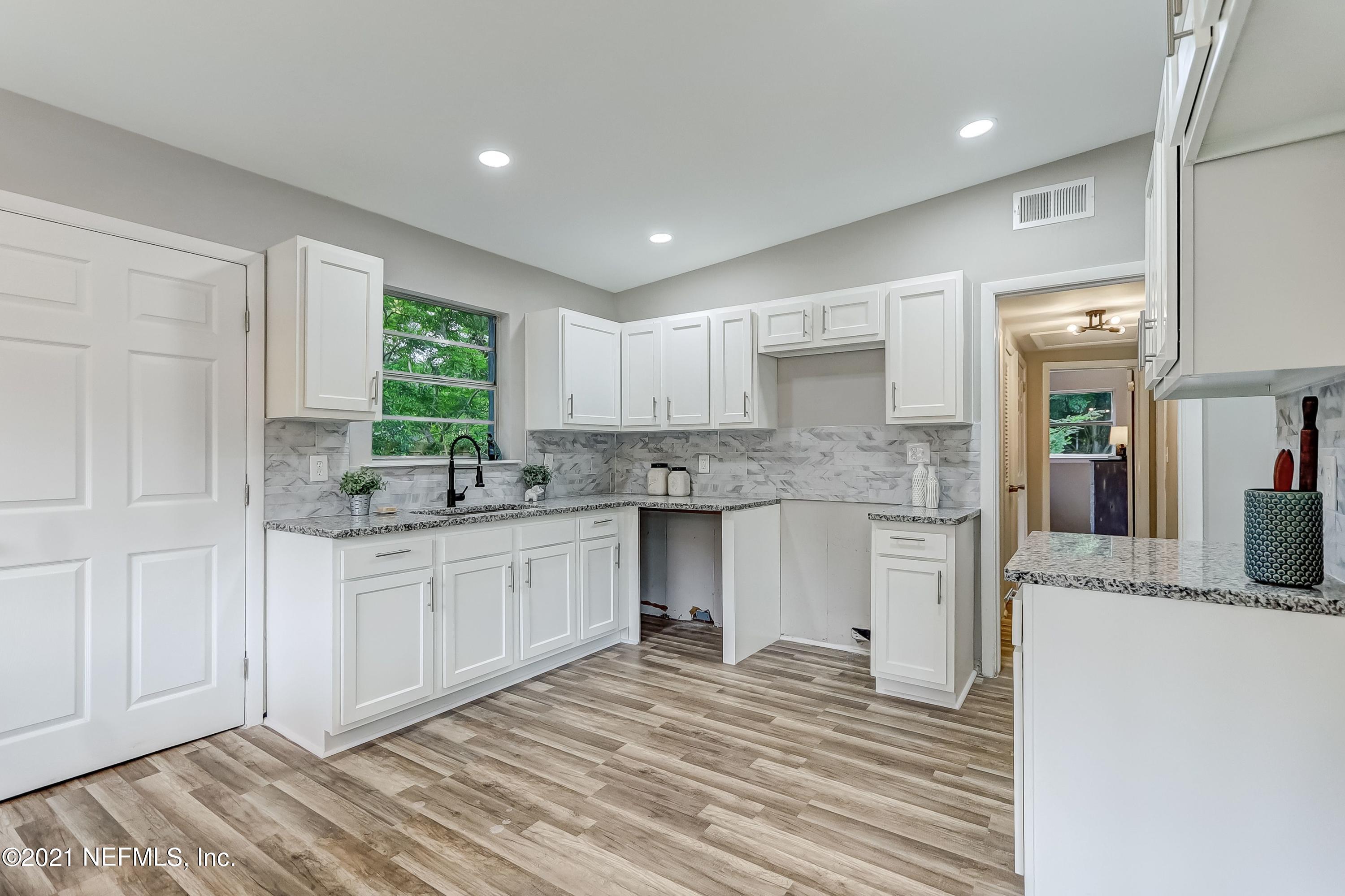 6914 Rollo Road Jacksonville, FL 32205 - Photo 13 of 31 a kitchen with granite countertop a sink and cabinets