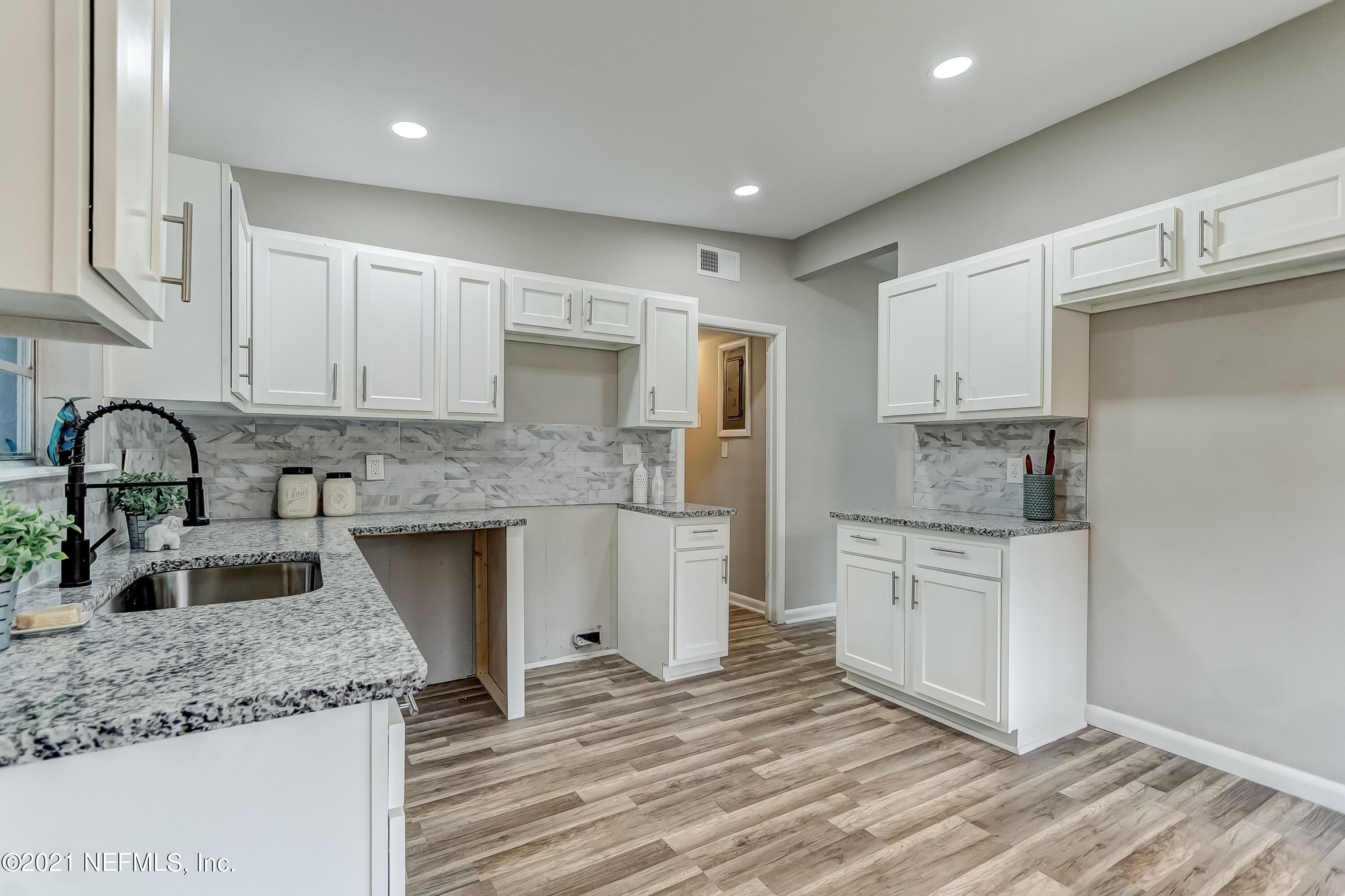 6914 Rollo Road Jacksonville, FL 32205 - Photo 14 of 31 a kitchen with granite countertop a sink stove and cabinets