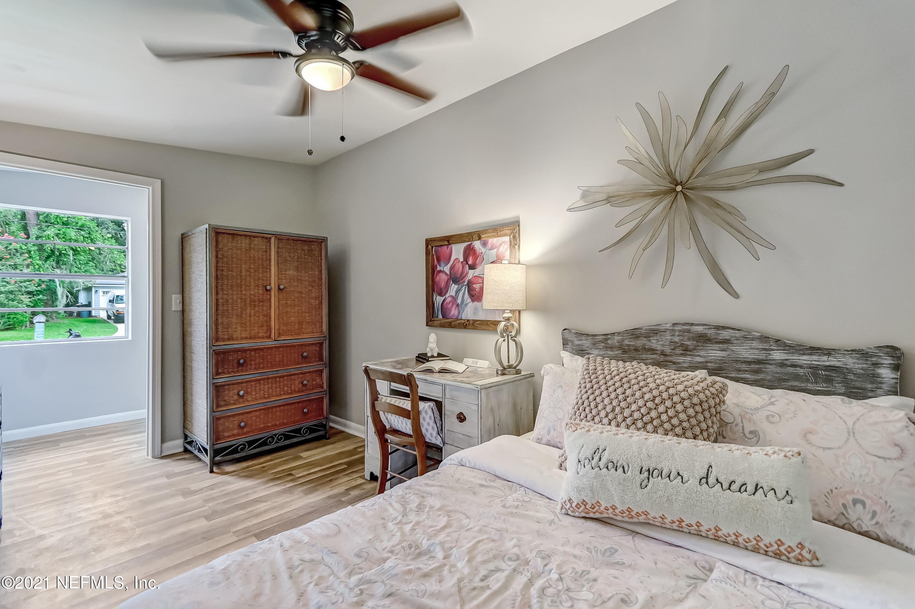 6914 Rollo Road Jacksonville, FL 32205 - Photo 17 of 31 a bedroom with a bed and a chandelier