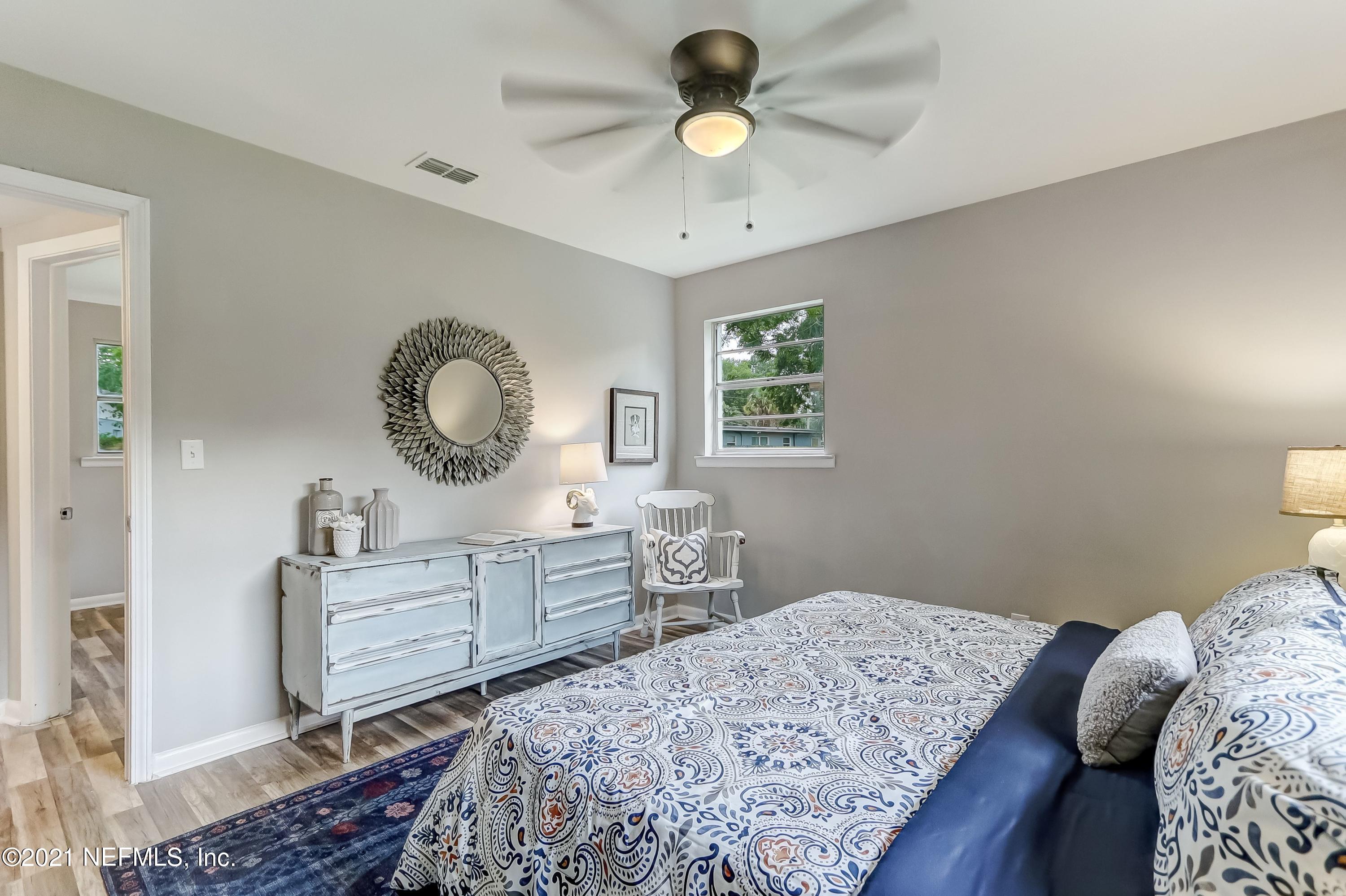 6914 Rollo Road Jacksonville, FL 32205 - Photo 22 of 31 a bedroom with a bed and a chandelier