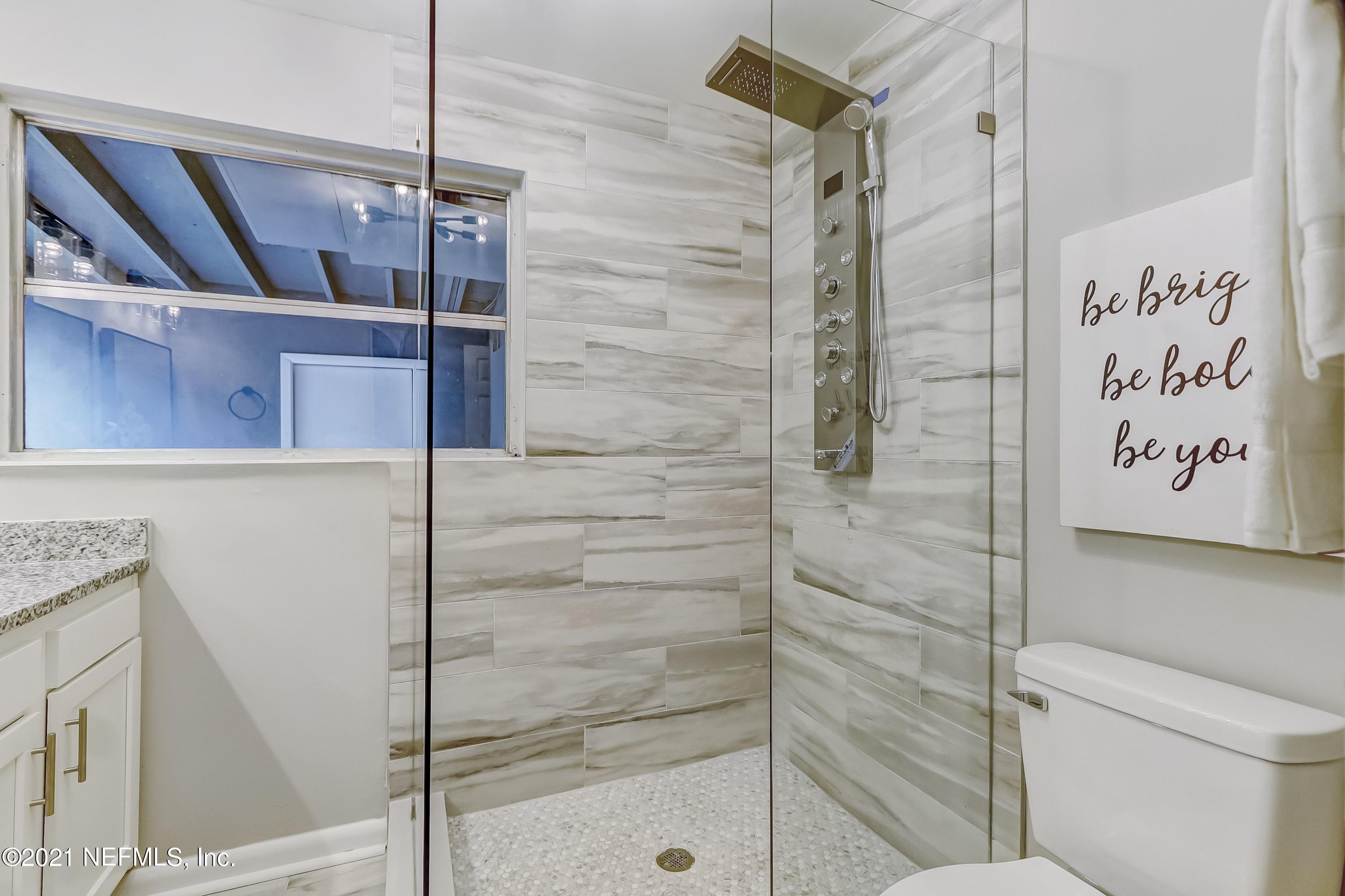 6914 Rollo Road Jacksonville, FL 32205 - Photo 26 of 31 a bathroom with a shower and a glass door