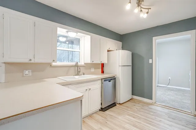 a kitchen with a sink a refrigerator and window