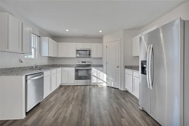 a kitchen with a refrigerator a sink and cabinets