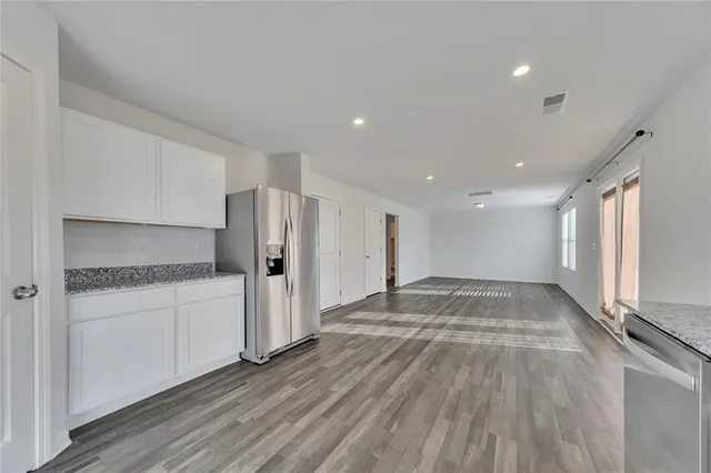 a view of a refrigerator in kitchen and wooden floor