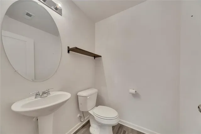 a bathroom with a sink mirror and toilet