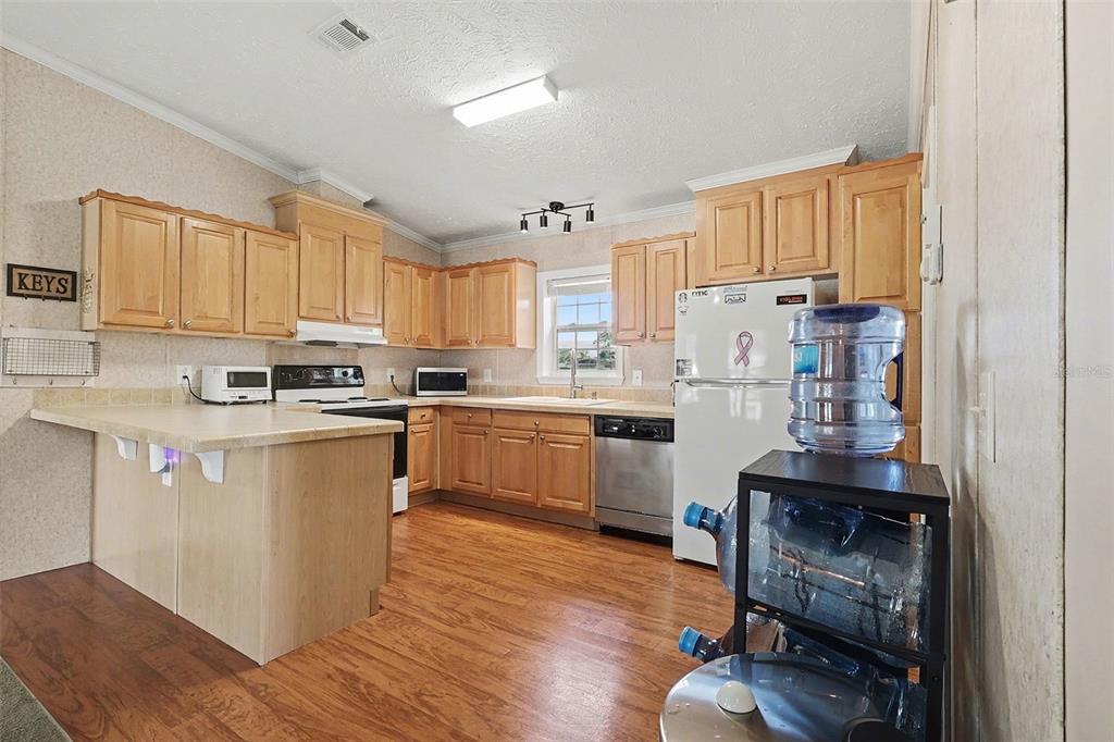 11305 Pineapple Road Punta Gorda, FL 33955 - Photo 9 of 30 a kitchen with granite countertop wooden floors and white stainless steel appliances