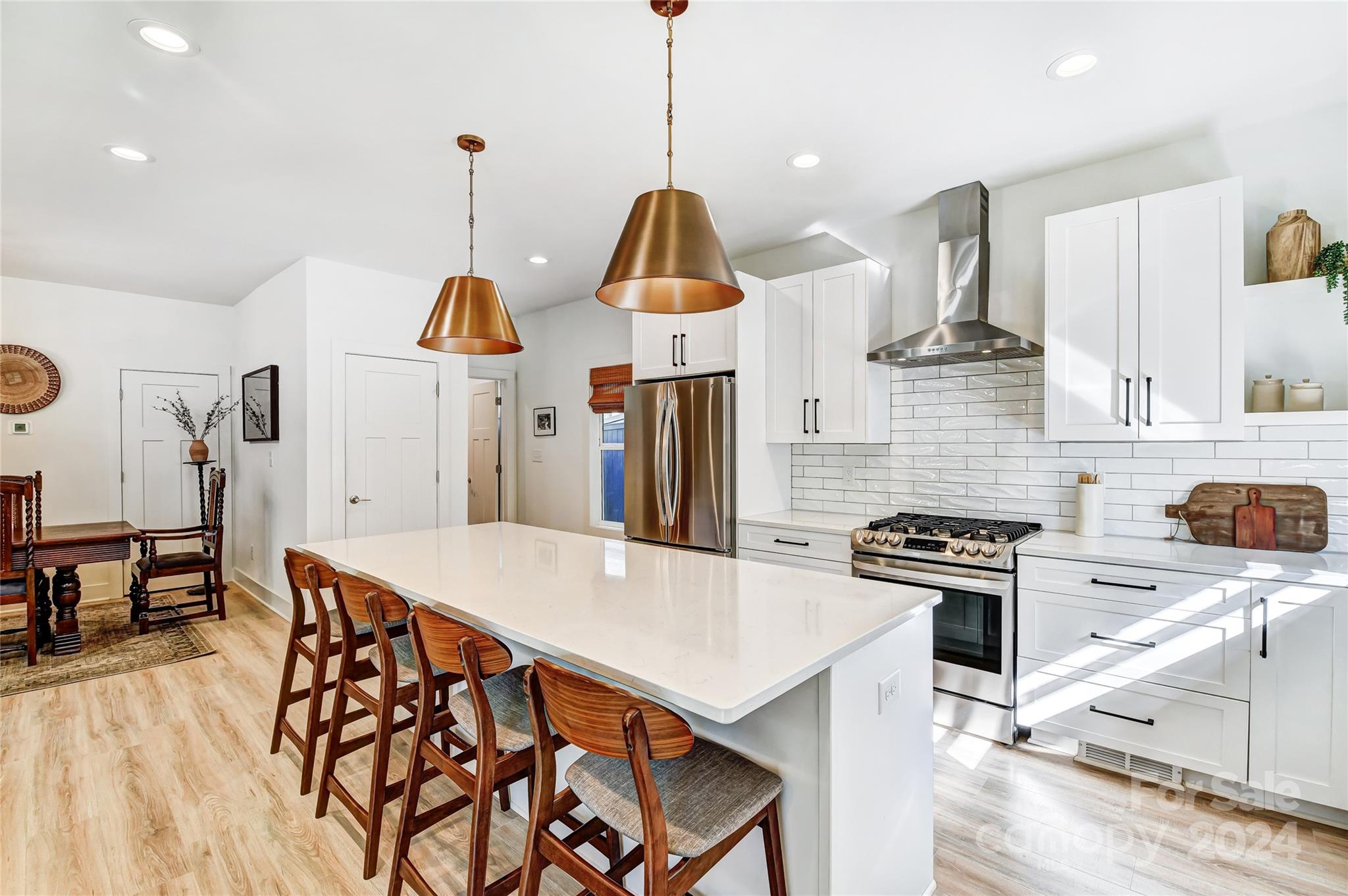 526 Seldon Drive Charlotte, NC 28216 - Photo 11 of 46 a kitchen with stainless steel appliances granite countertop a stove a sink a oven a dining table and chairs with wooden floor