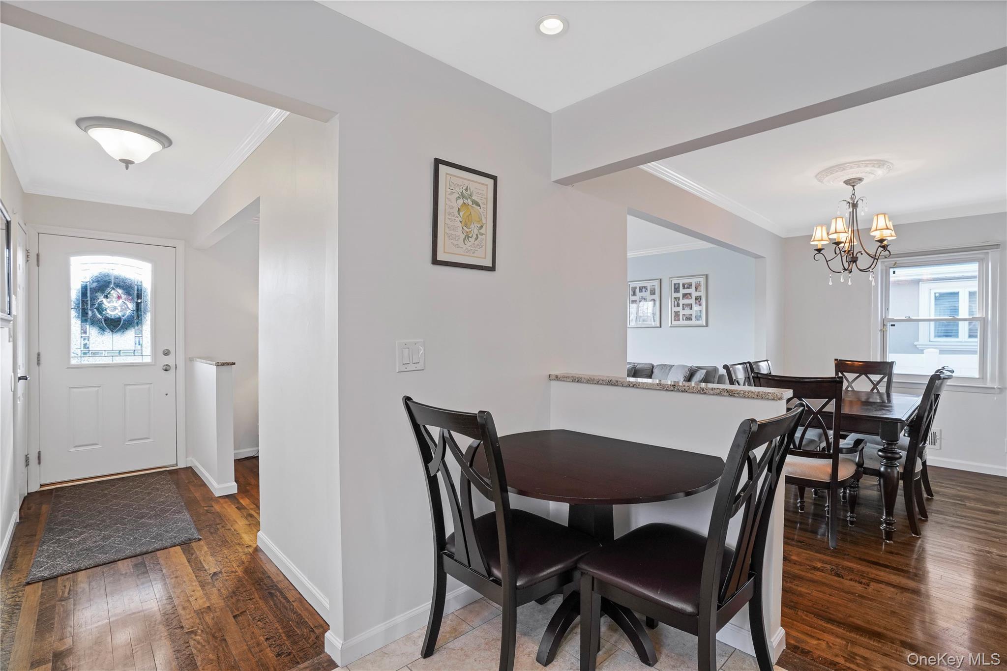 91-03 156th Avenue Queens, NY 11414 - Photo 13 of 50 Dining room featuring healthy amount of natural light, dark wood finished floors, crown molding, and a chandelier