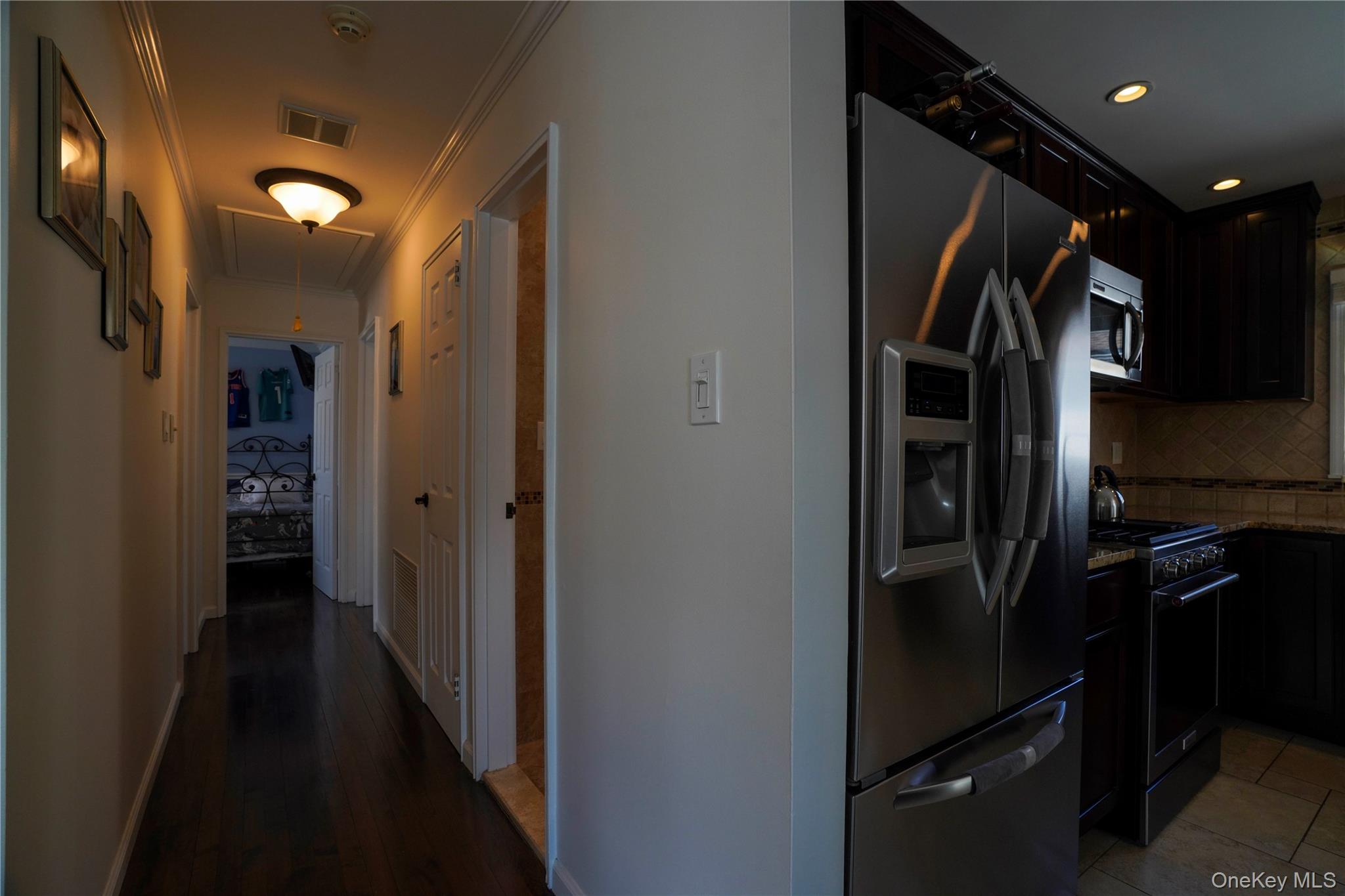 91-03 156th Avenue Queens, NY 11414 - Photo 17 of 50 Kitchen with appliances with stainless steel finishes, decorative backsplash, dark stone counters, crown molding, and dark brown cabinetry