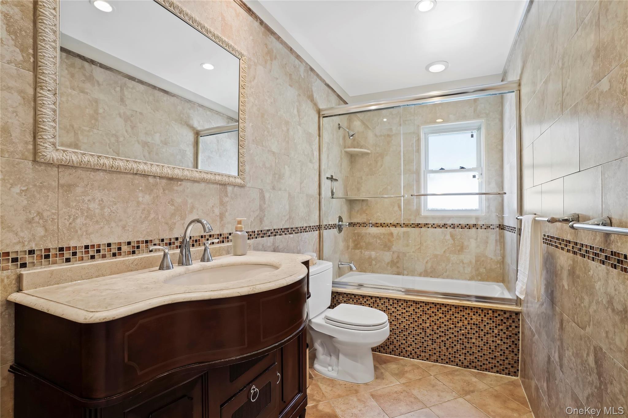 91-03 156th Avenue Queens, NY 11414 - Photo 25 of 50 Bathroom featuring tile walls, vanity, light tile patterned floors, tiled shower / bath combo, and recessed lighting