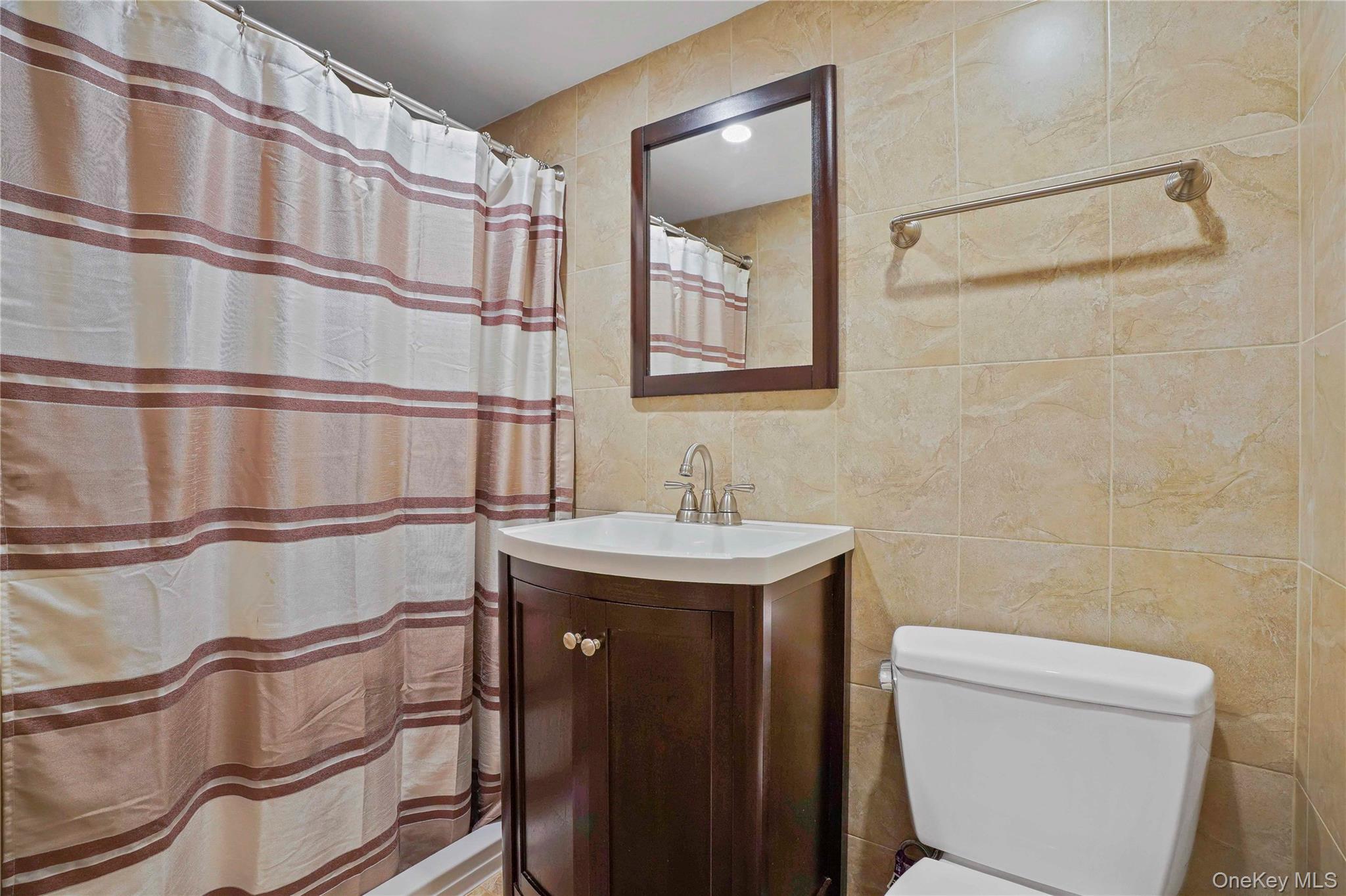 91-03 156th Avenue Queens, NY 11414 - Photo 35 of 50 Bathroom with tile walls, a shower with curtain, and vanity