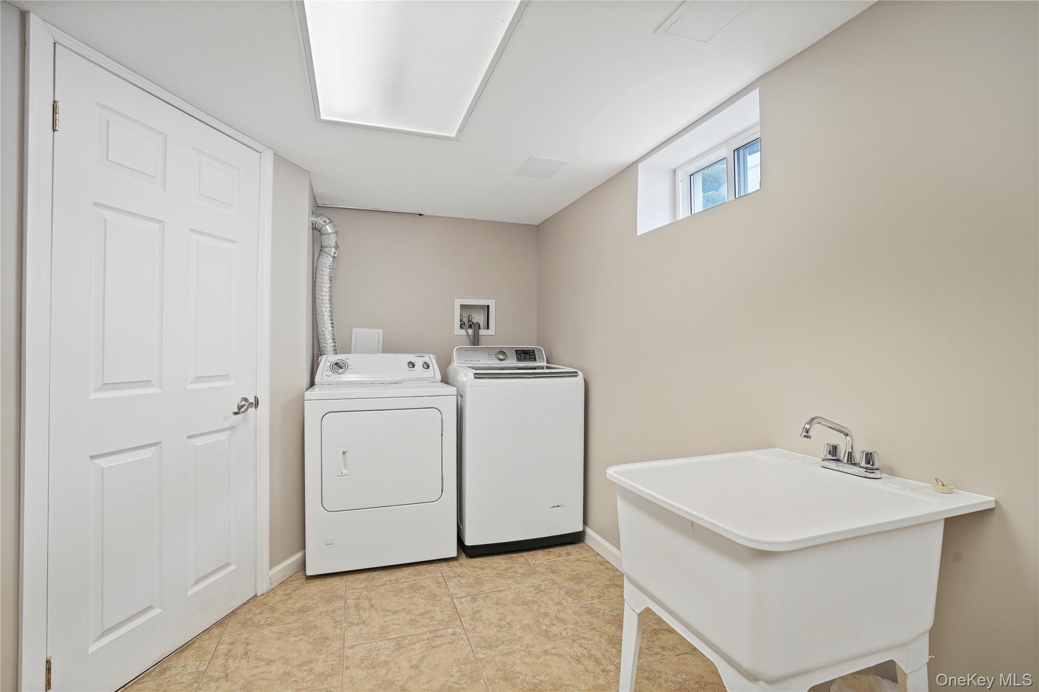 91-03 156th Avenue Queens, NY 11414 - Photo 38 of 50 Washroom featuring washing machine and clothes dryer and light tile patterned floors