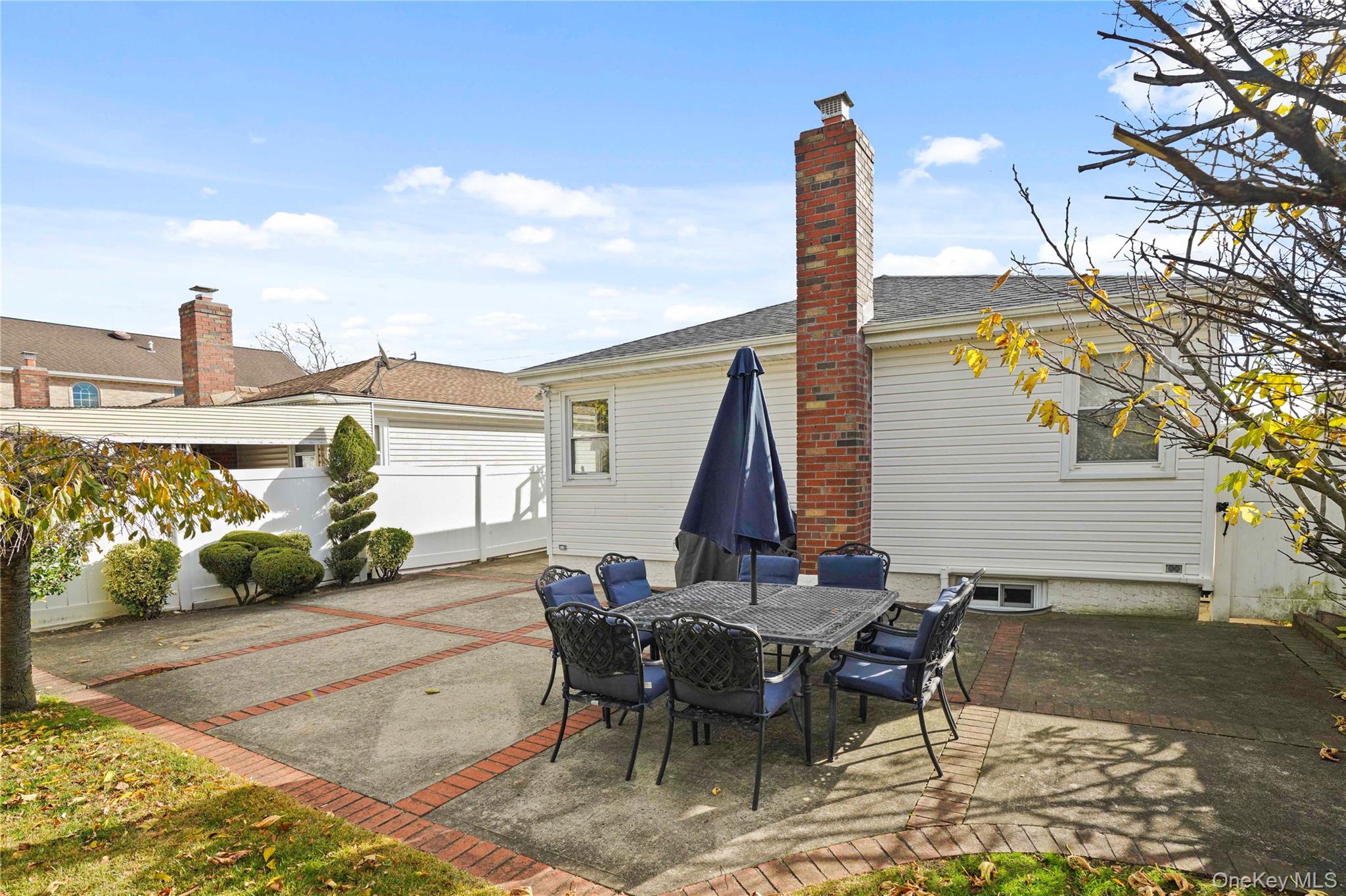 91-03 156th Avenue Queens, NY 11414 - Photo 42 of 50 Back of property with a patio area, outdoor dining space, a chimney, and roof with shingles