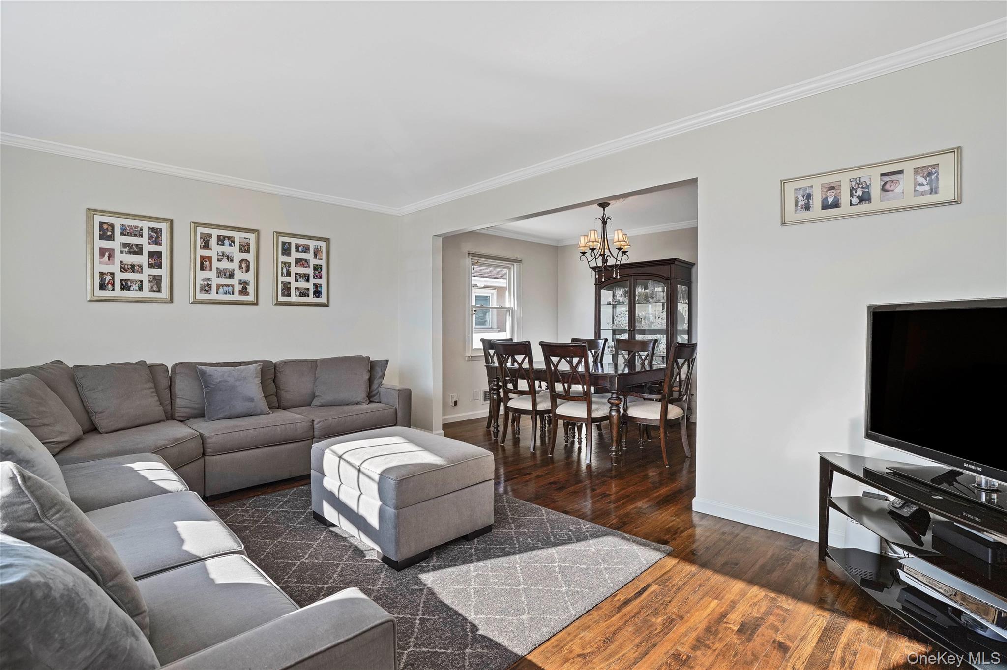 91-03 156th Avenue Queens, NY 11414 - Photo 5 of 50 Living area featuring crown molding, dark wood-style floors, and a chandelier