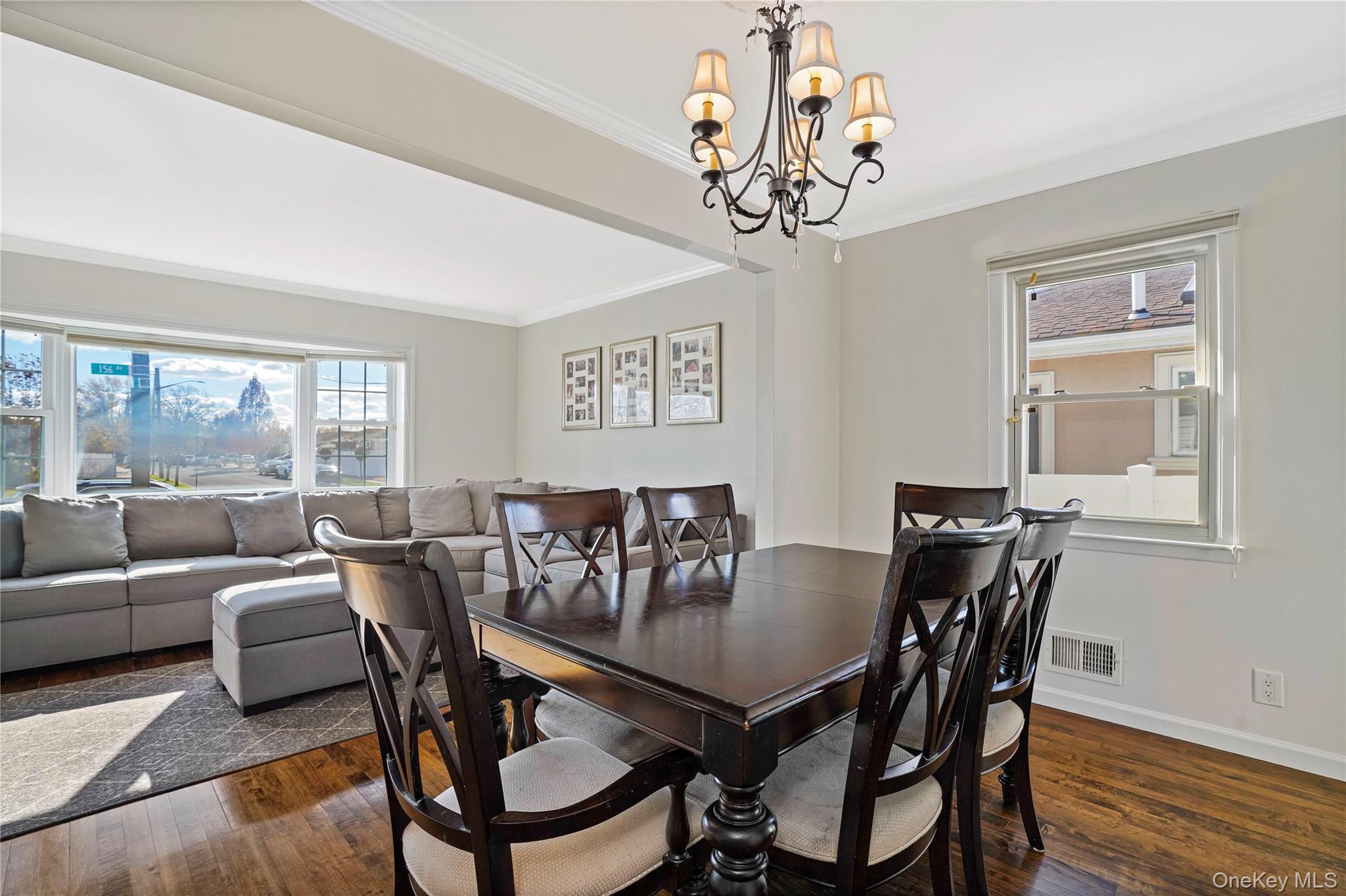 91-03 156th Avenue Queens, NY 11414 - Photo 9 of 50 Dining room with crown molding, dark wood-style flooring, and a chandelier