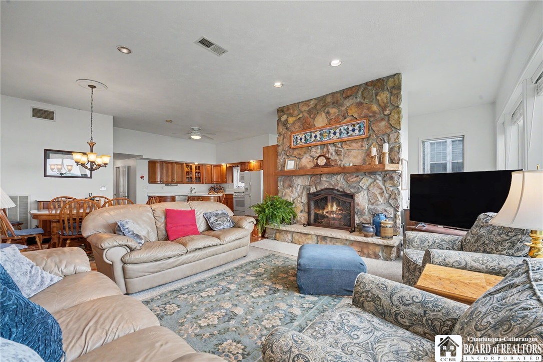 4568 Warners Bay Road Ellery, NY 14712 - Photo 14 of 43 Vacation-style living room with a cozy stone gas