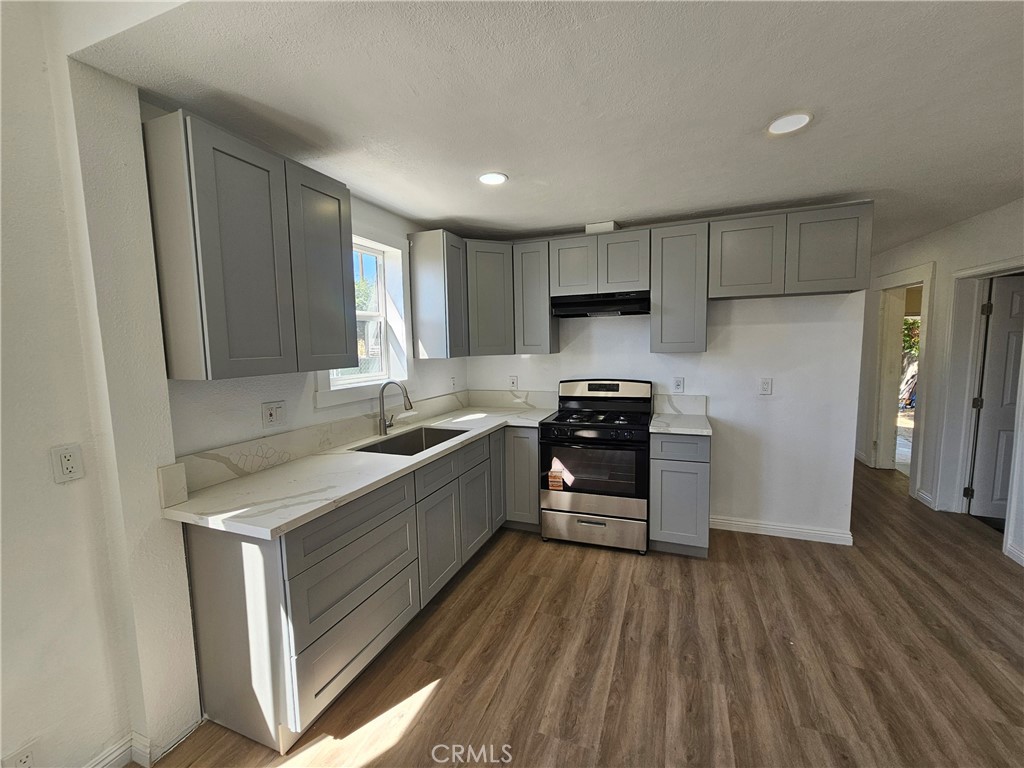 207-207 East O Street Colton, CA 92324 - Photo 7 of 26 a kitchen with granite countertop a refrigerator stove and sink