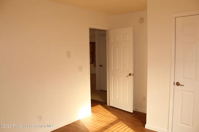 a view of a bedroom with wooden floor