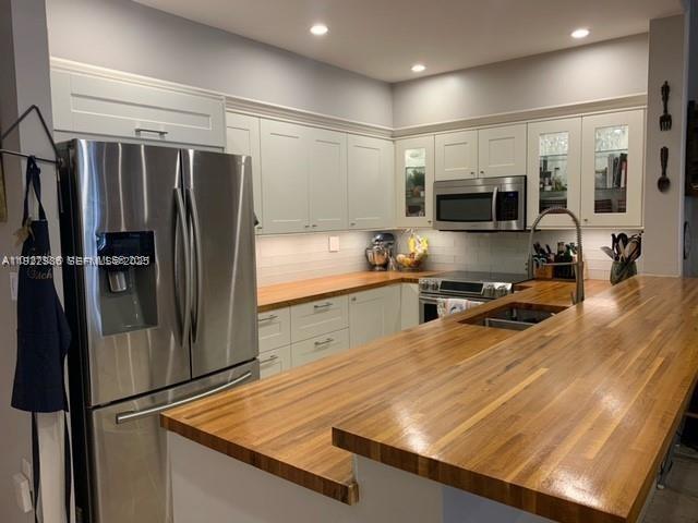 14803 Breckness Place Miami Lakes, FL 33016 - Photo 2 of 9 a kitchen with stainless steel appliances a refrigerator and a stove top oven