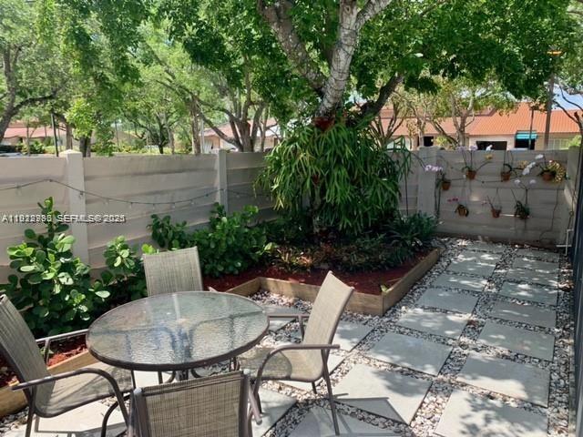 14803 Breckness Place Miami Lakes, FL 33016 - Photo 8 of 9 a backyard with table and chairs potted plants and large tree