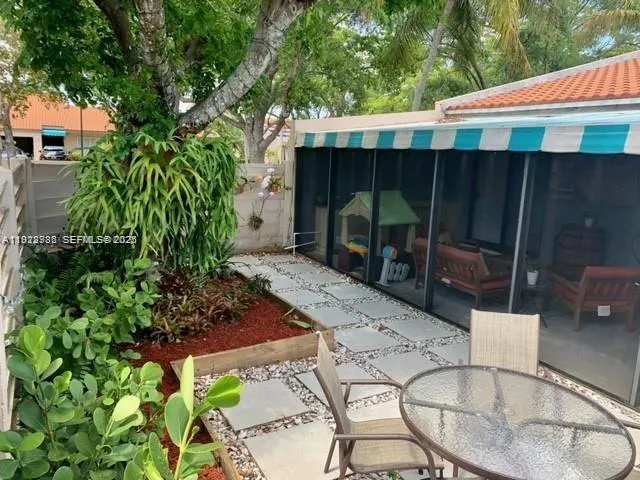 a backyard of a house with barbeque oven table and chairs
